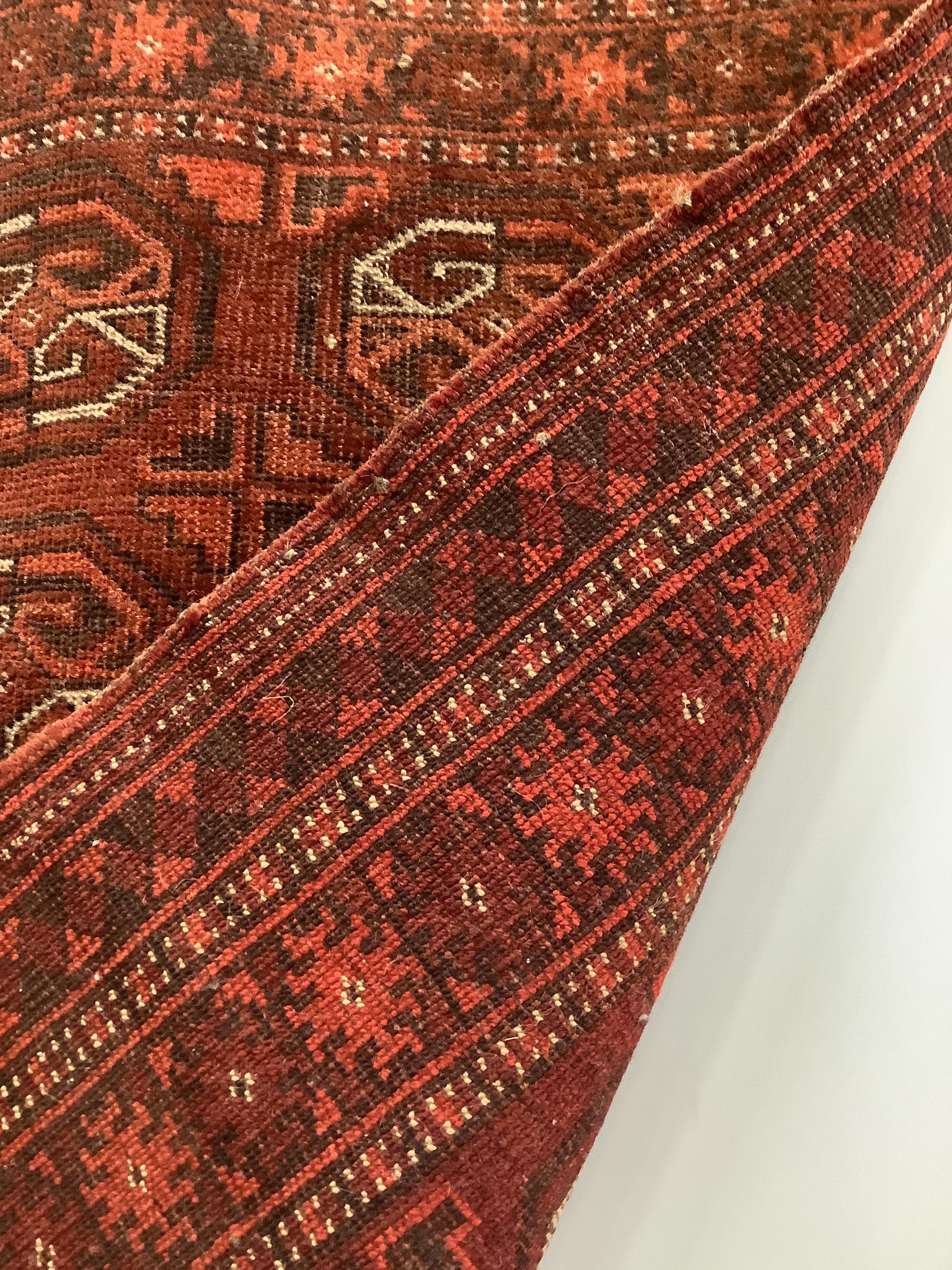 A Bokhara red ground rug, 100 x 72cm
